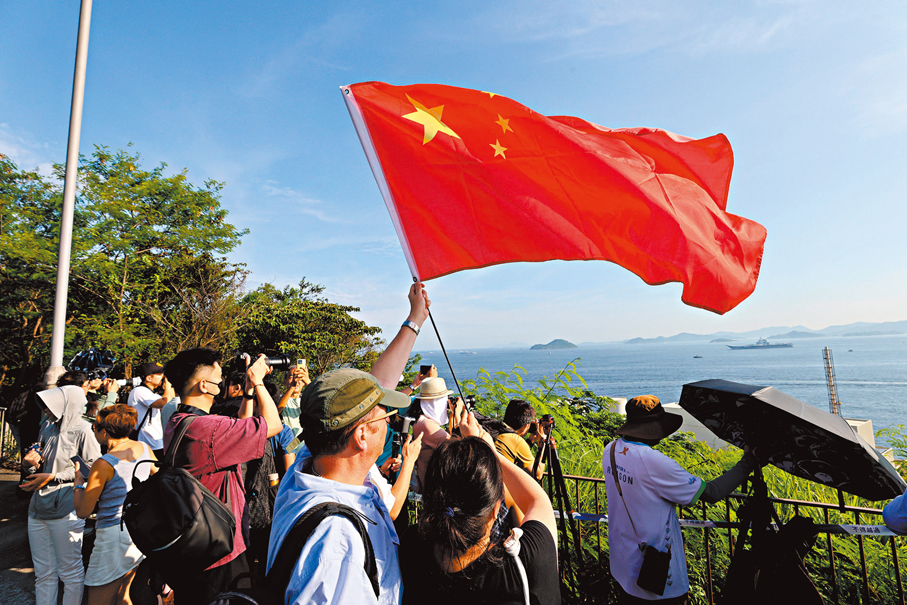 ●意大利籍港人Mr. Giuliano與太太一起揮舞五星紅旗。 香港文匯報記者北山彥 攝