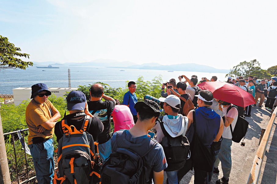 ●32度高溫下，無阻市民觀看航母的熱情。 香港文匯報記者北山彥  攝