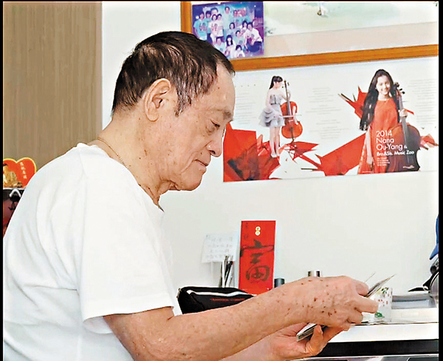 ●傅德澤在翻看老照片。 視頻截圖