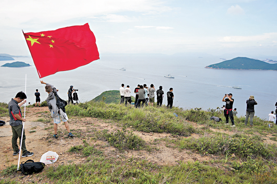 ●市民朱先生日前在玉桂山揮舞國旗迎接山東艦編隊訪港。 大公文匯全媒體記者麥鈞傑 攝