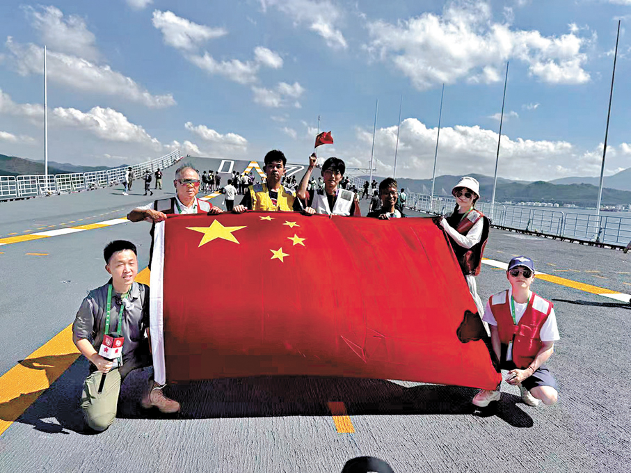 ●市民阿兵（左一）和朱先生（右三）終於如願帶着那面在玉桂山揮舞迎接艦隊的國旗登上山東艦。大公文匯全媒體記者謝光輝  攝