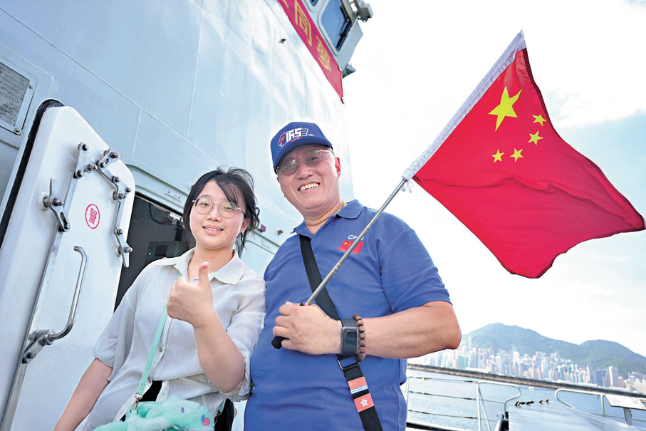 ●陳先生與女兒手持五星紅旗登艦參觀。 大公文匯全媒體記者蔡文豪  攝