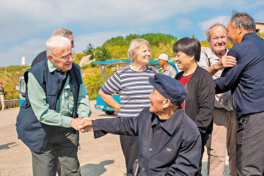 ●親歷者後代與中國漁民林阿根握手。