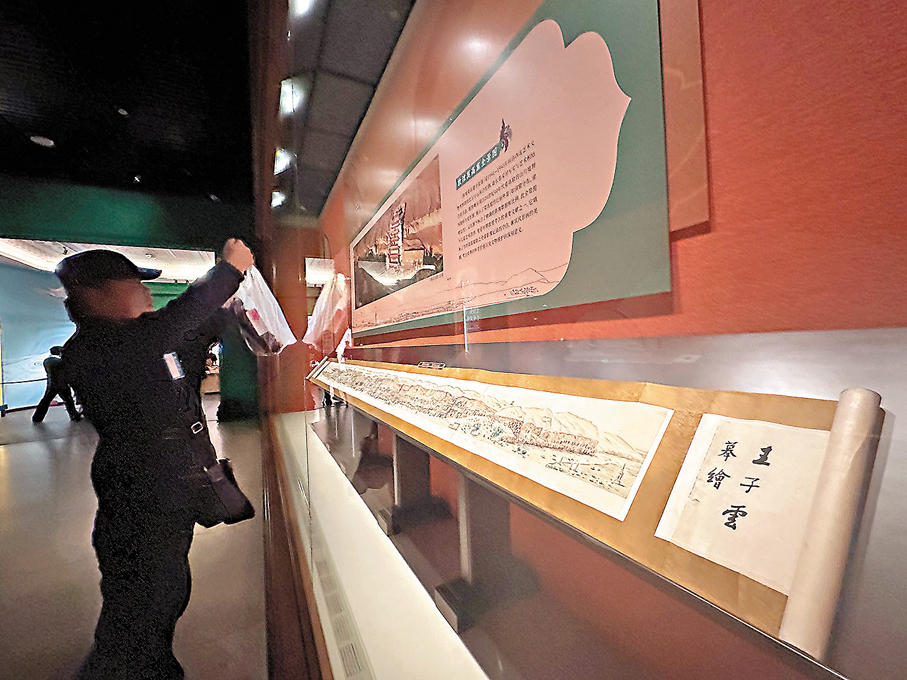 ●觀眾在觀看敦煌研究院收藏的《敦煌千佛崖（莫高窟）全景圖》。