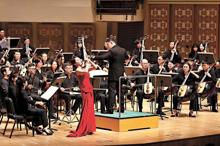 ●劉雯雯一襲紅裙，吹響嗩吶。