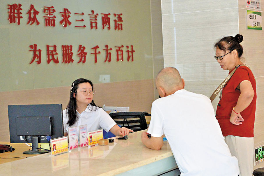 ●整治形式主義為基層減負，是中央連續6年專門部署推動的重要工作。圖為基層工作人員在重慶市沙坪壩區井口街道美麗陽光家園社區黨群服務中心為市民服務。 網上圖片