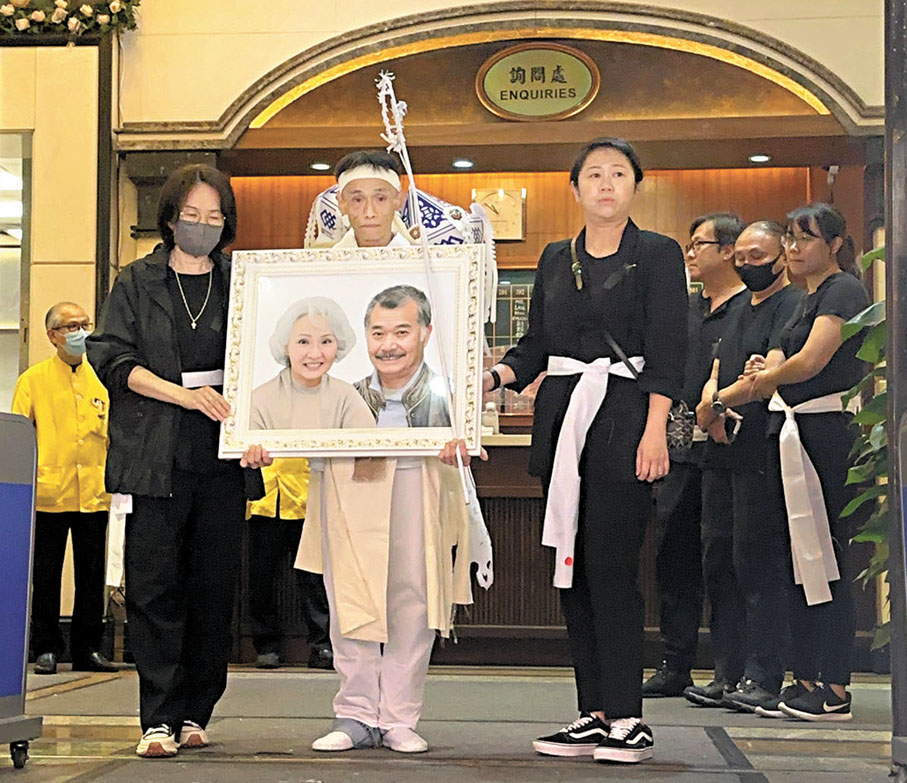 ●佳哥和雪妮的兒子手捧遺照神情哀傷。 子棠  攝