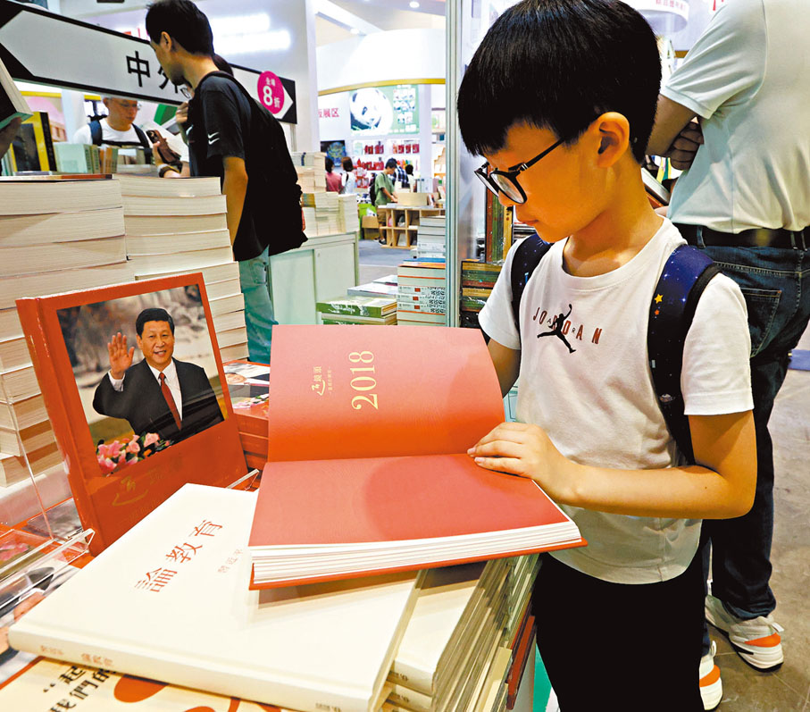 ●一名學生在書展上翻看《近鏡頭:溫暖的瞬間》。香港文匯報記者曾興偉 攝