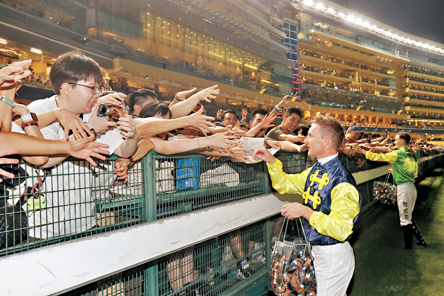 ●一眾騎師向場內馬迷致意並派發紀念品，慶祝2024/25年度馬季結束。 馬會供圖