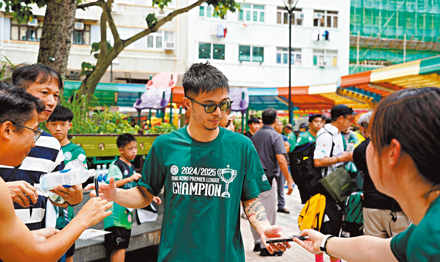 ●大埔球星陳肇鈞巡遊期間，逐一為球迷簽名。