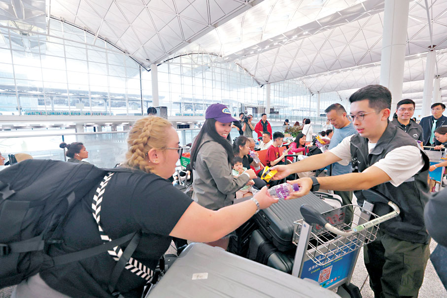 ●機管局工作人員派發水和乾糧給滯留旅客。香港文匯報記者北山彥  攝