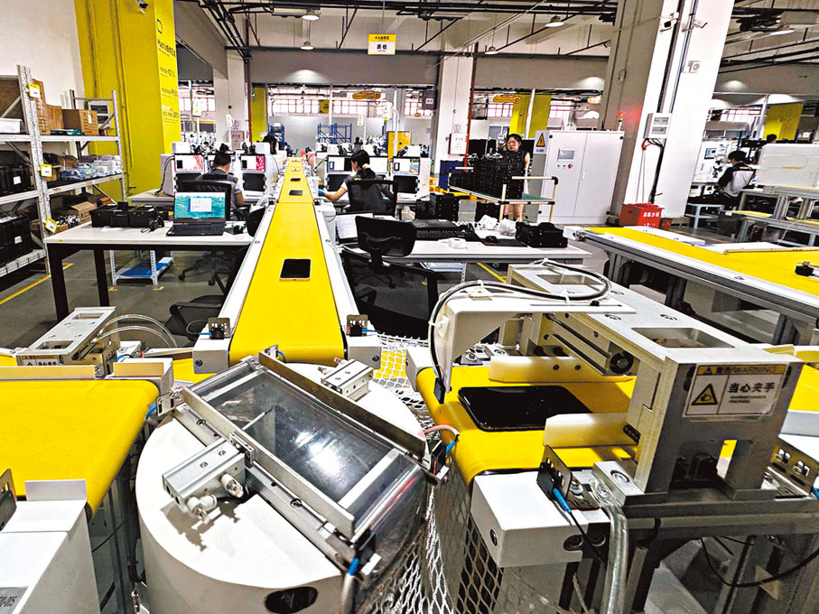 ●在中心內，一台台貼着標籤碼的舊手機被放上黃色傳送帶，接受「AI體檢」。