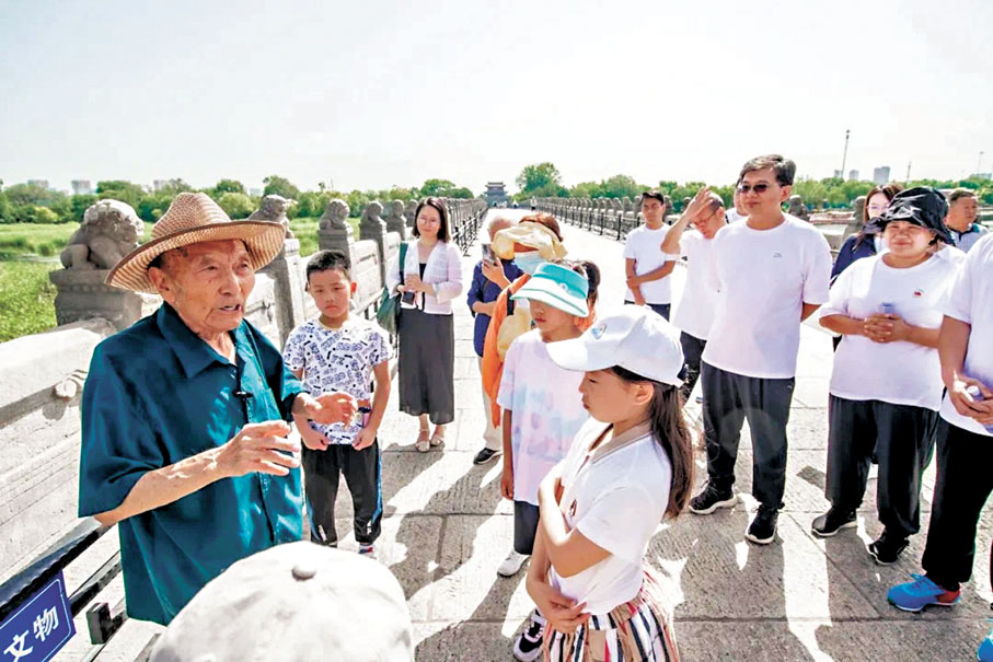 ●鄭福來不懼風吹日曬，在橋上為世界各地的遊客免費講解抗戰往事。