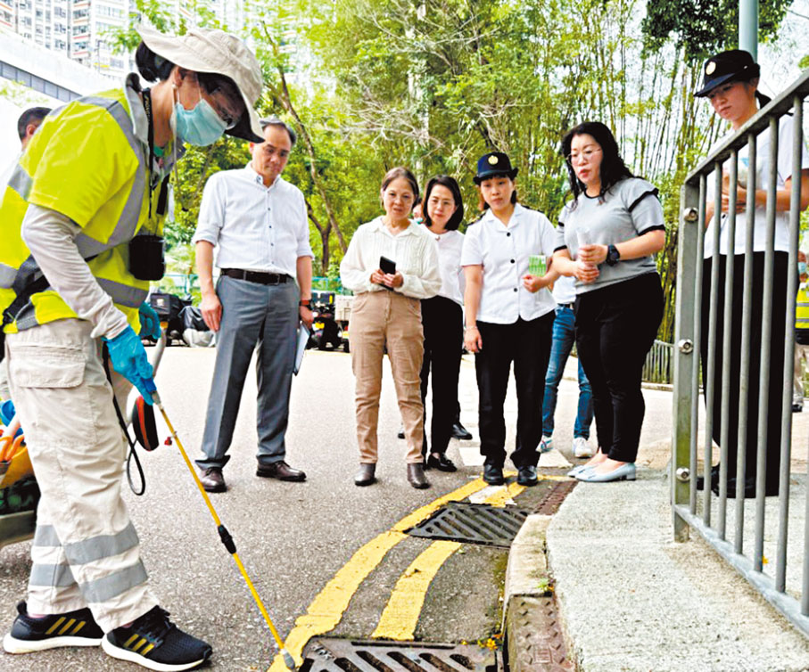 ●環境及生態局副局長黃淑嫻（左三）一行人視察食環署人員在排水渠口噴灑滅蚊油。