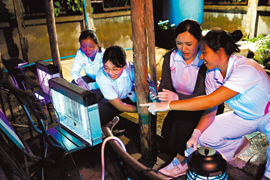 ●陳卓瑜（左一）實習時期深夜檢查滅蚊燈捕捉的昆蟲數量。 受訪者供圖