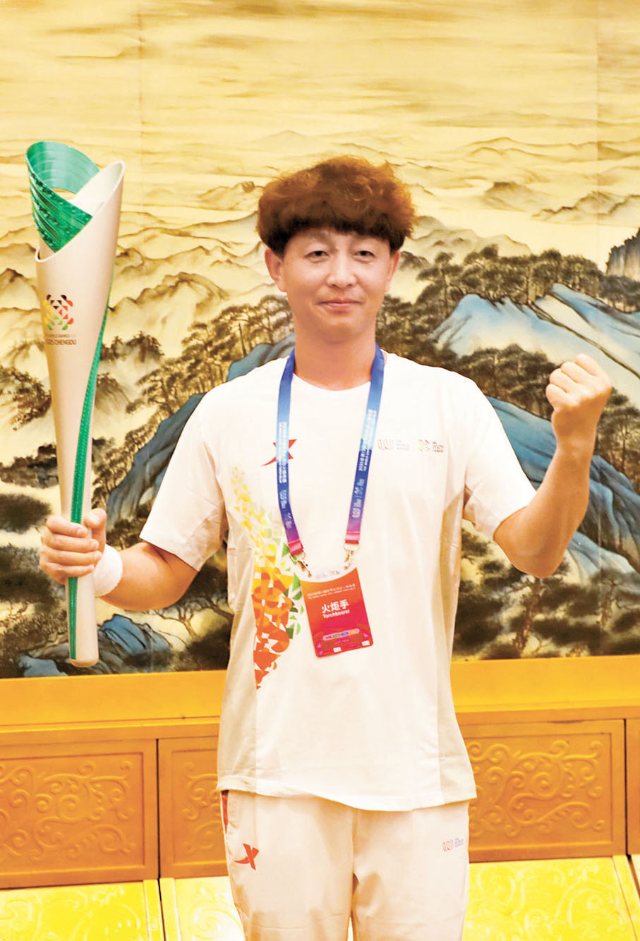 ●第32棒火炬手曾小龍展示火炬。   香港文匯報記者李兵 攝