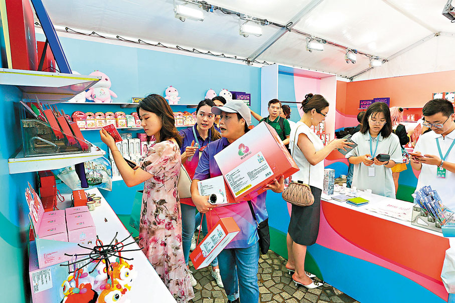 ●巿民在全運會商品特許零售店揀選紀念品。香港文匯報記者北山彥 攝