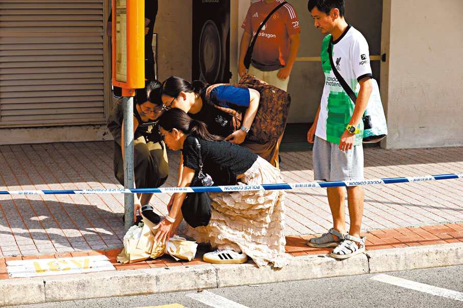 ●前日事發後有市民到悅來酒店外墮樓現場放下鮮花哀悼。 資料圖片