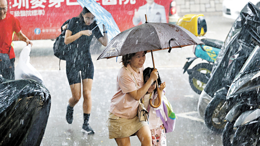 ●天文台發出今年首個黑雨，市民狼狽過馬路。 香港文匯報記者黃艾力  攝