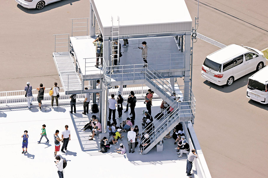 ●日本北海道民眾烈日下到高處暫避。美聯社