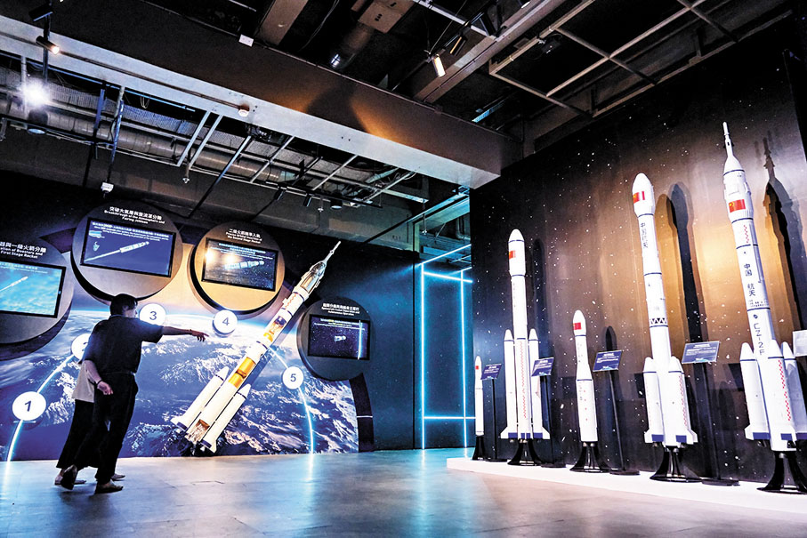 ●左邊為展示船箭分離與飛船自主運行過程的解說圖，右邊為火箭與載人飛船模型。 中通社