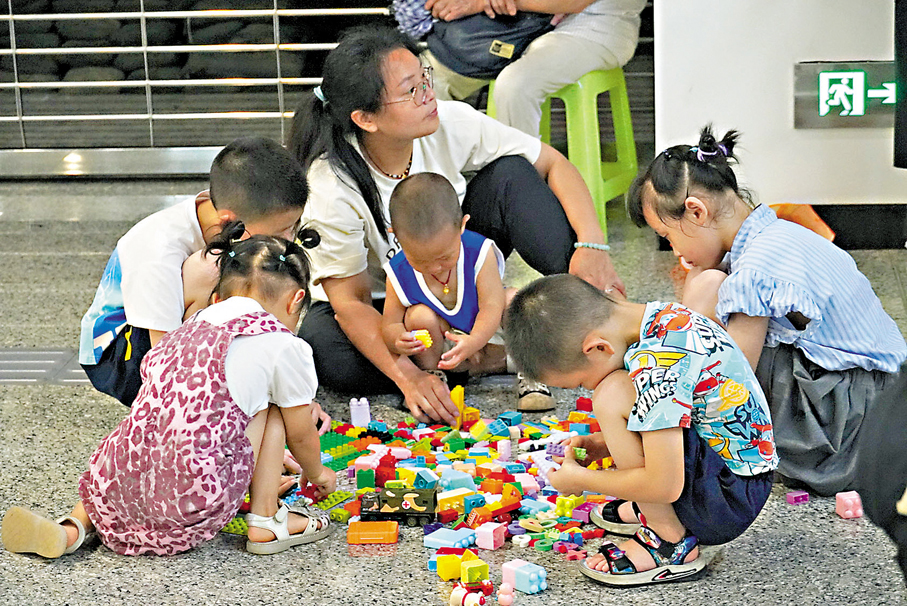 ●重慶奧體中心地鐵站內正在玩積木的孩子們。 香港文匯報記者孟冰  攝