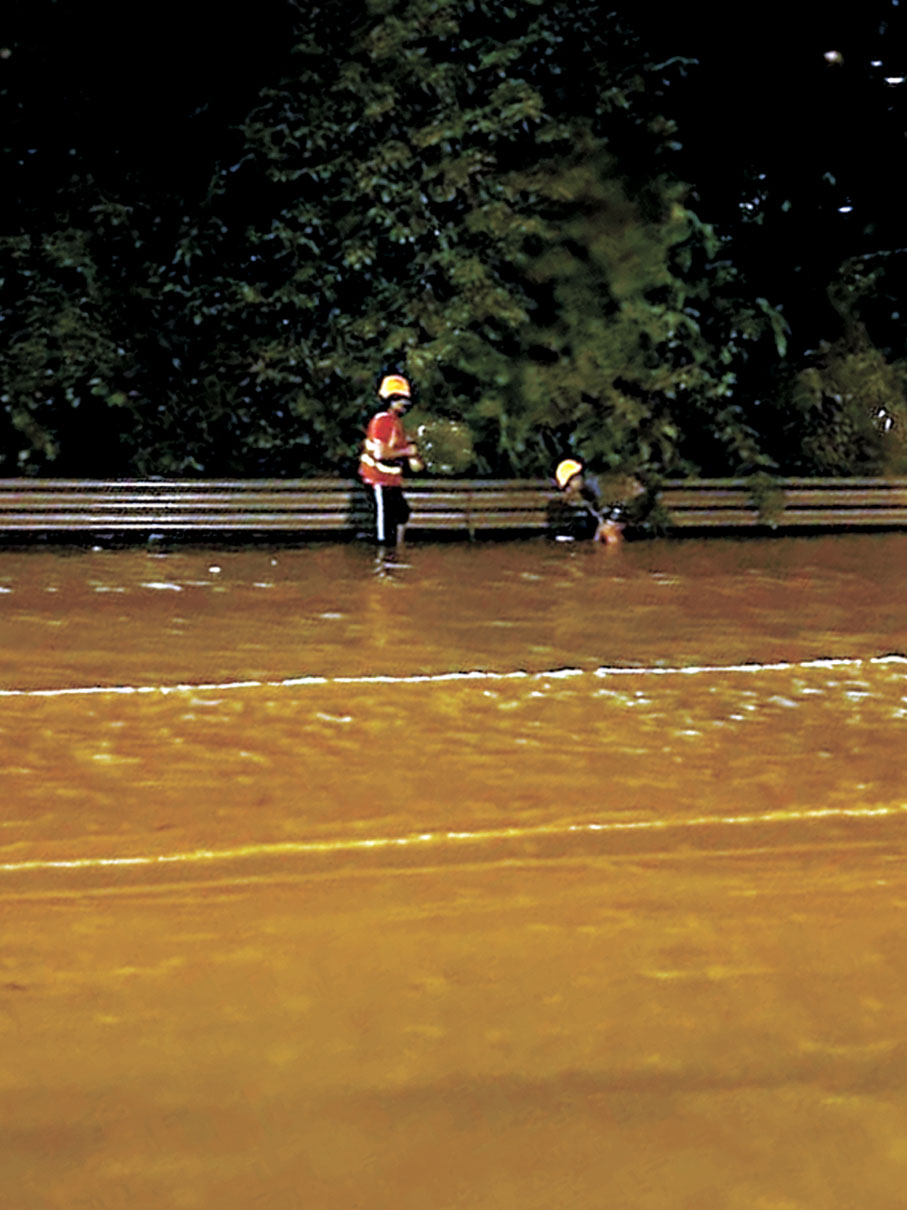 ●吐露港公路近梅樹坑昨日早上水浸，渠務署工人冒雨疏通渠道。
