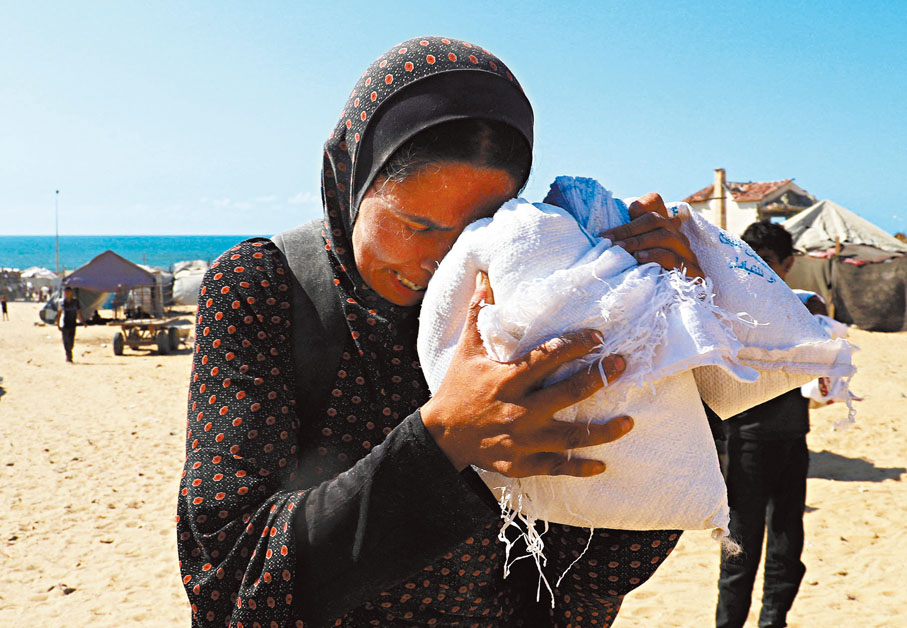 ●加沙婦人取得物資後不禁悲從中來。 路透社