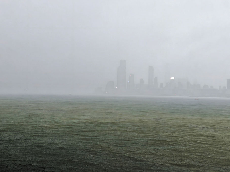 ●昨日黑雨襲港逾11小時，港股仍維持買賣。圖為黑色暴雨下維港一片霧色茫茫。   香港中通社