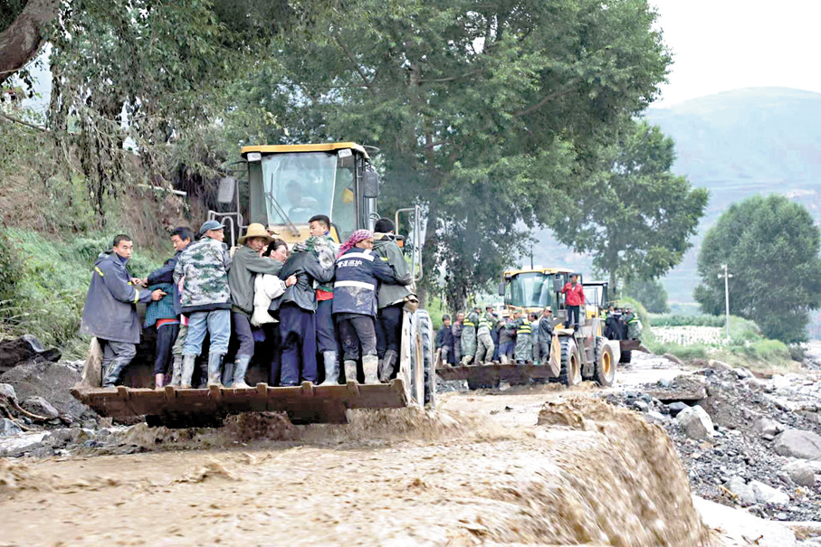 ●8月8日，在甘肅蘭州市榆中縣馬坡鄉馬蓮灘村，救援人員在組織受災群眾轉移。   新華社