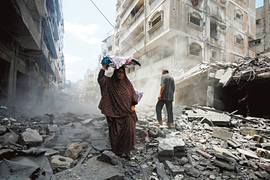 ●巴人在加沙城視察被毀社區的情況。 路透社