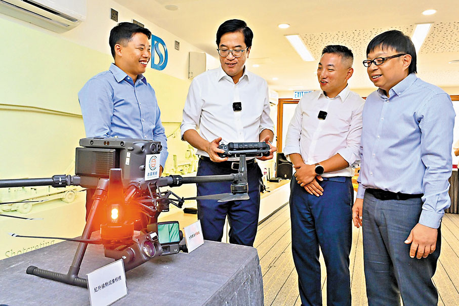 ●黃偉綸（左二）了解無人機的技術突破和操作。