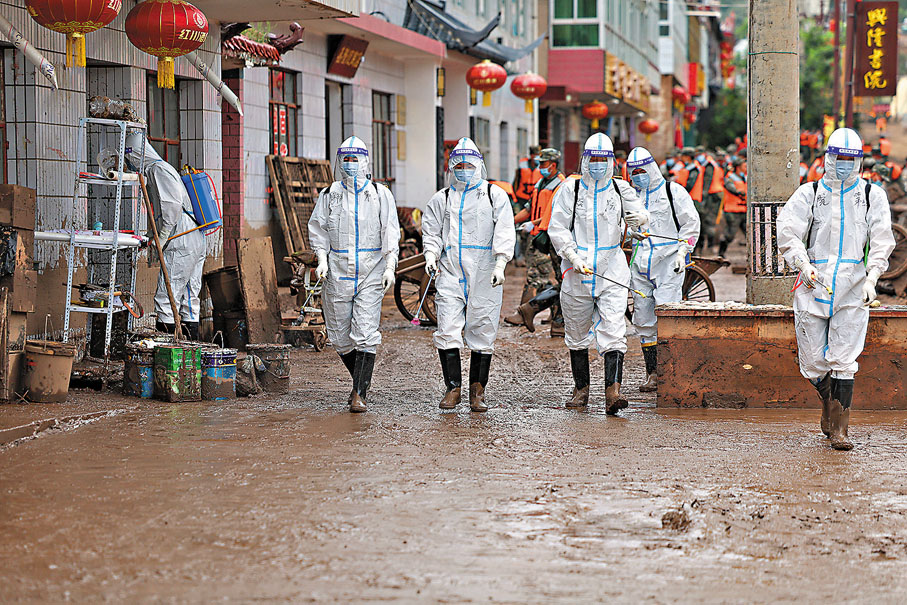 ●8月10日，武警甘肅總隊醫院衞勤分隊官兵在蘭州市榆中縣受災街道進行防疫消殺。 新華社