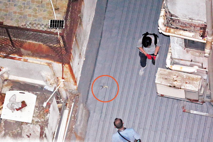 ●調查人員在涉案大廈天台發現懷疑兇器。 香港文匯報記者鄧偉明  攝