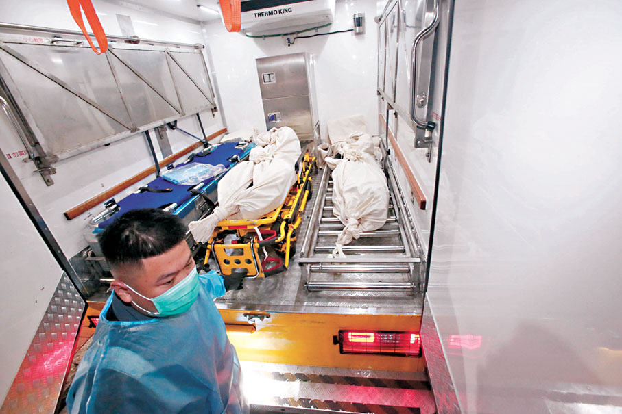 ●母子遺體由仵工舁送殮房。 香港文匯報記者鄧偉明  攝