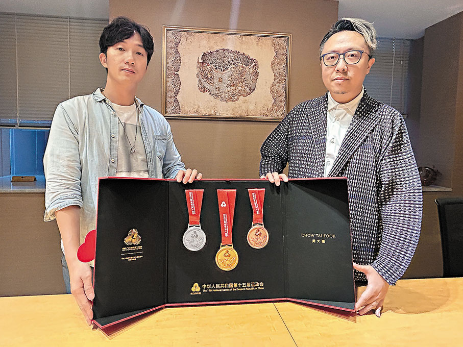 ●獎牌設計師林鴻勝（右）和黎偉傑在採訪時展示樣品。香港文匯報記者敖敏輝  攝