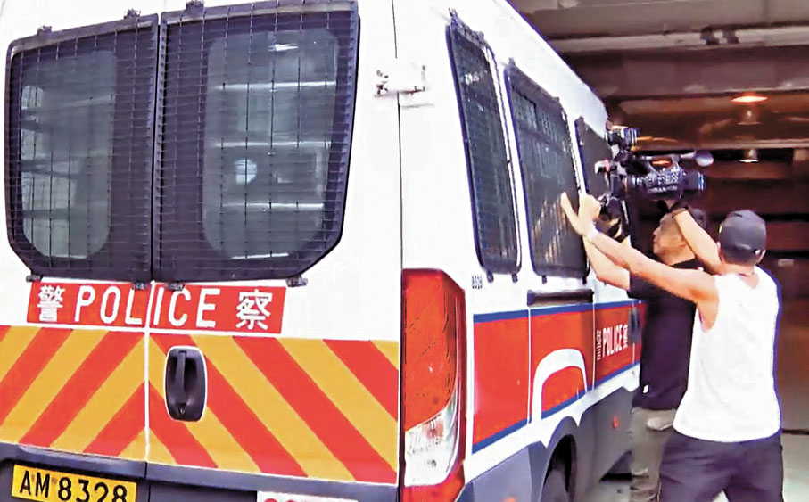 ●涉將尿液加入樽裝汽水的被捕男子由警車押解到法院。電視截圖