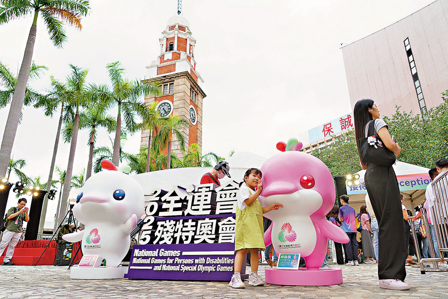 ●7月12日，一名小朋友在尖沙咀十五運(yùn)會(huì)和殘?zhí)貖W會(huì)吉祥物裝置前拍照。  資料圖片
