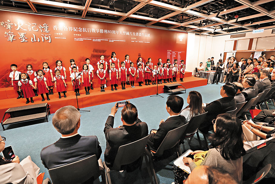 ●「烽火記憶 筆墨山河」香港各界紀念抗日戰爭勝利80周年大型圖片及書畫作品展昨日開幕，一班小朋友在台上獻唱。