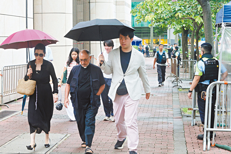 ●黎智英妻李韻琴及幼子黎順恩（兩名持傘者）到庭旁聽。 香港文匯報記者郭木又  攝