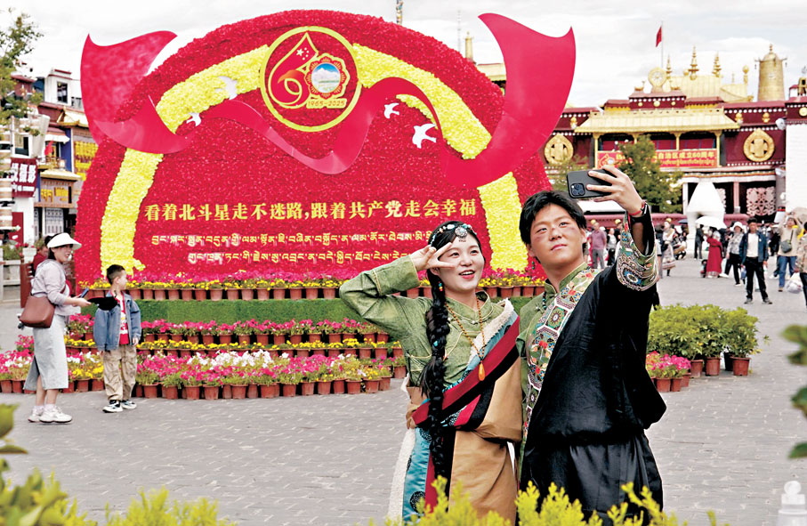 ●8月19日,遊客在拉薩大昭寺廣場上的花壇前拍照留念。 中新社