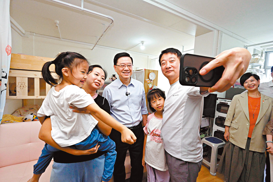 ●李家超(左三)和何永賢(右一)探訪居住在「簡約公屋」的張先生一家。