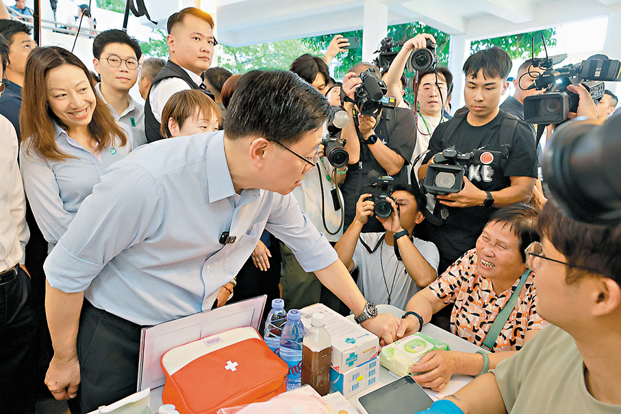 ●李家超前往關愛隊服務攤位,了解其為市民提供的健康檢查。 香港文匯報記者北山彥 攝
