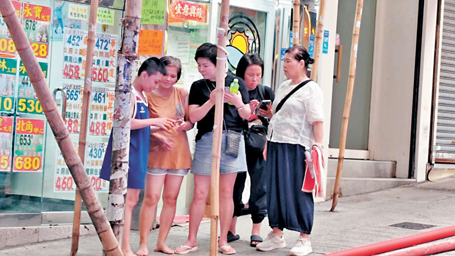 ●由搭棚師傅救上天台的其中兩母子(左一及左二)赤腳逃生。 資料圖片