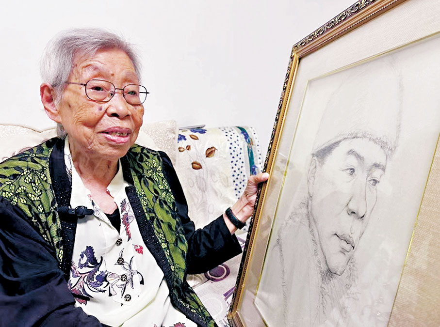 ●桑桂芳接受香港文匯報記者採訪，手扶畫像為父親桑元慶。香港文匯報記者于海江  攝