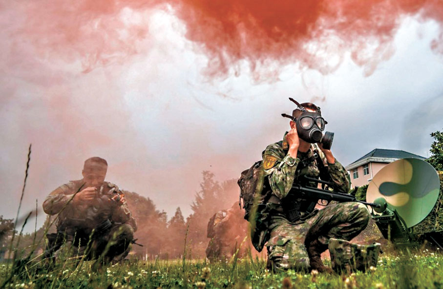 ●火箭軍某部進行實戰化全流程全要素綜合演練。圖為官兵演練迅速穿戴防護裝具。