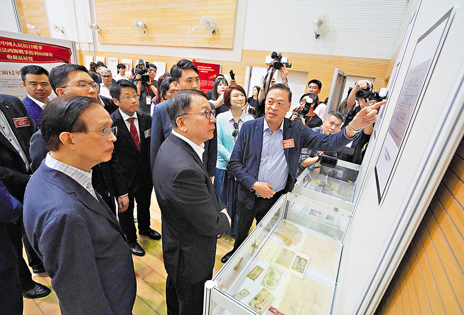 ●陳國基參觀展覽,聆聽唐卓敏講解資料。 香港文匯報記者曾興偉 攝