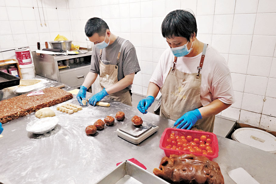 ●師傅熟練地揉麵和包餡料製作唐餅。香港文匯報記者涂穴  攝