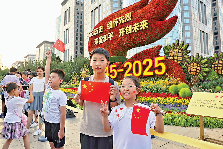 ●市民和遊客在紀念抗戰勝利80周年主題花壇打卡拍照。  中通社