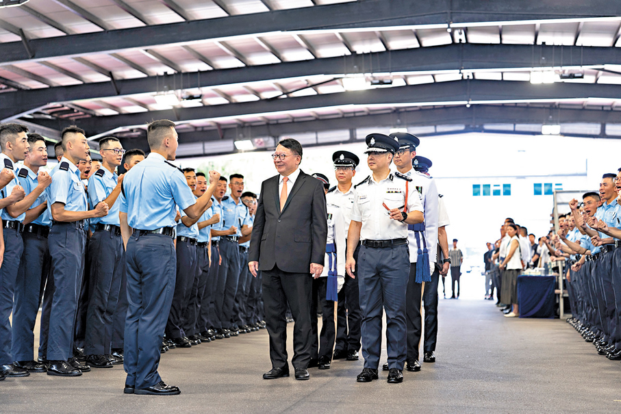 ●陳國基昨日出席香港警察學院的結業會操後，在警務處處長周一鳴（前排右一）陪同下，與結業學員會面。